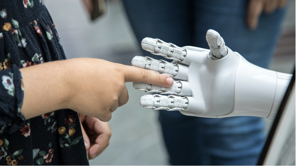 eine menschliche und eine Roboter-Hand berühren sich
