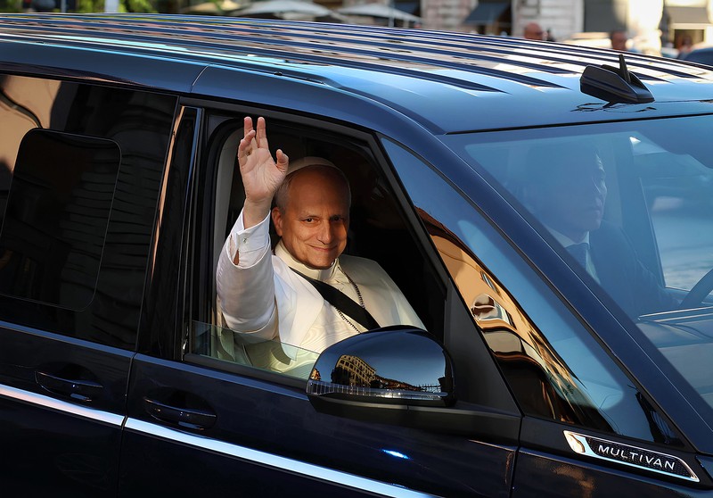 Papst Leo XIV. winkt aus dem Auto.