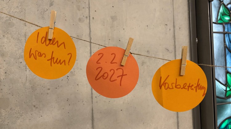 Zettel mit Ideen hängen an einer Schnur. Darauf steht: Ideen was tun, 2.2.2027, Vorbereitung